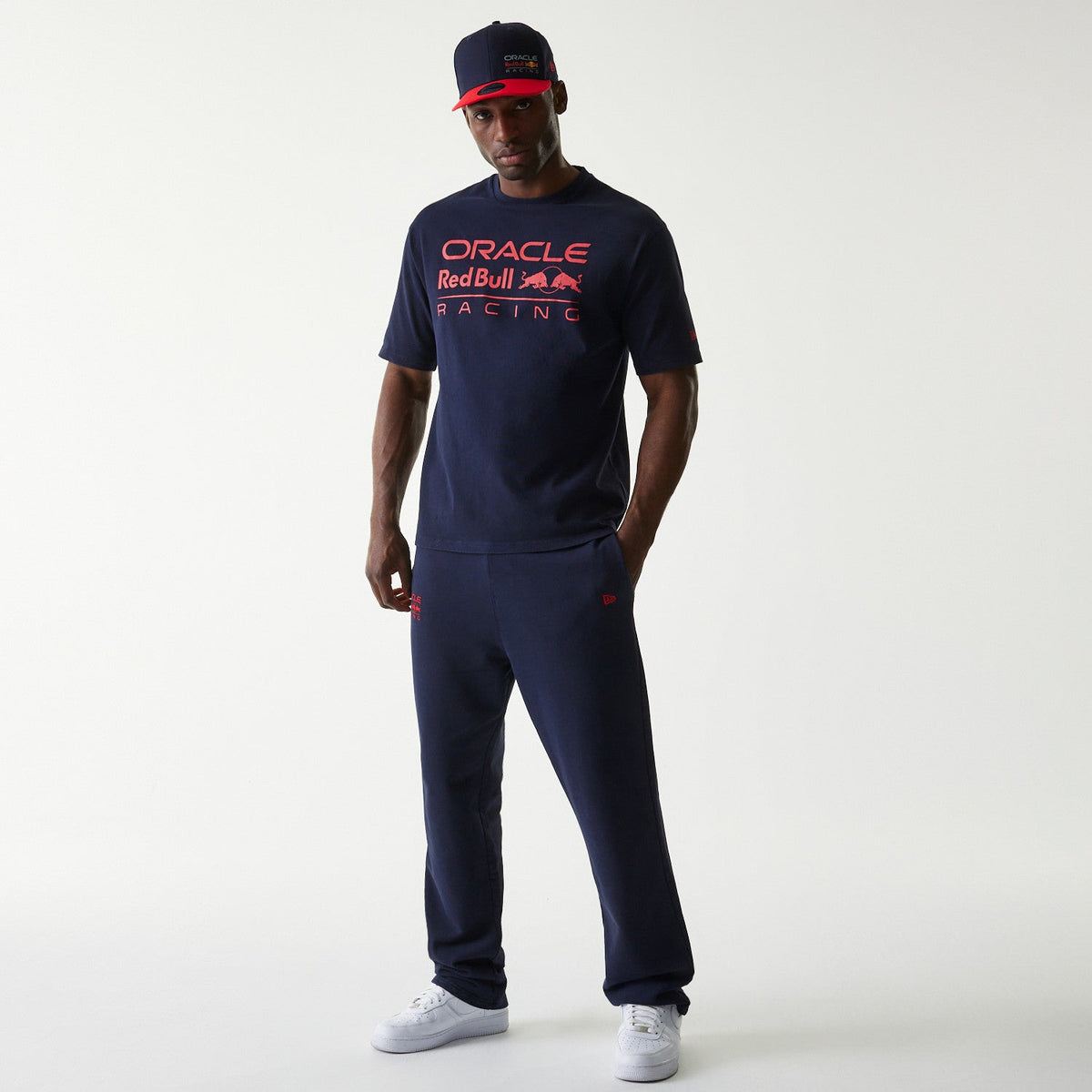 Model wearing navy joggers from the Oracle Red Bull Racing line with the Oracle logo on the right leg Forever REBL wordmark on the rear right and New Era Flag on the left pocket