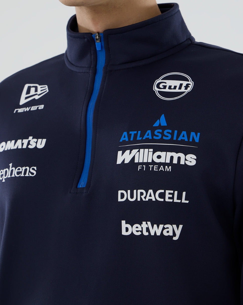 Navy half-zip sweatshirt with various brand logos on a plain background