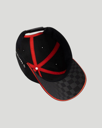 A black baseball cap with a red cross pattern on the front, a black and gray checkered pattern on the visor, and red piping along the edges, shown on a solid light gray background.