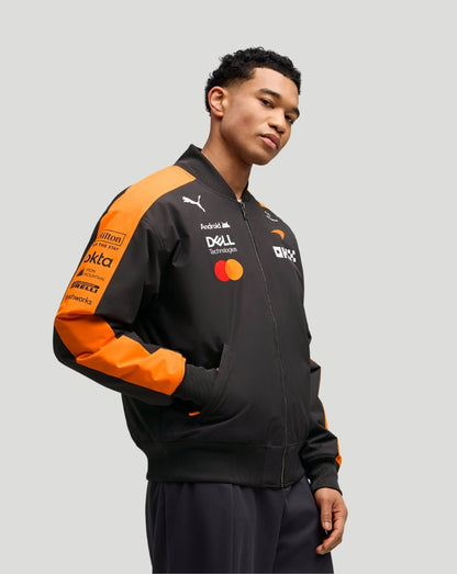Model wearing Papaya McLaren Team Bomber Jacket in black with orange sleeves and chest logos.