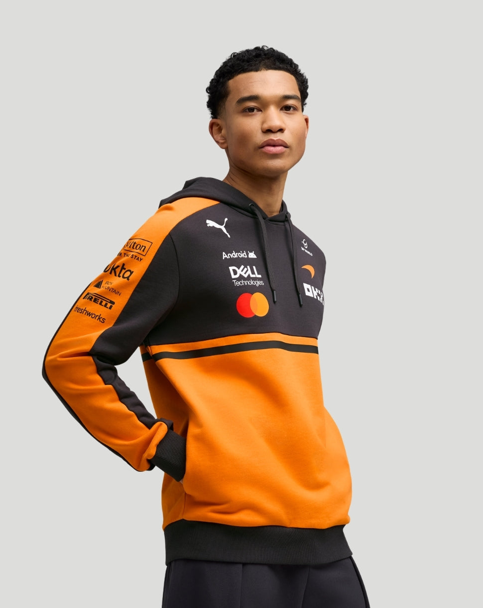 Front view of a model wearing Papaya McLaren Team Hoodie in orange and black with sponsor logos on the chest and sleeve