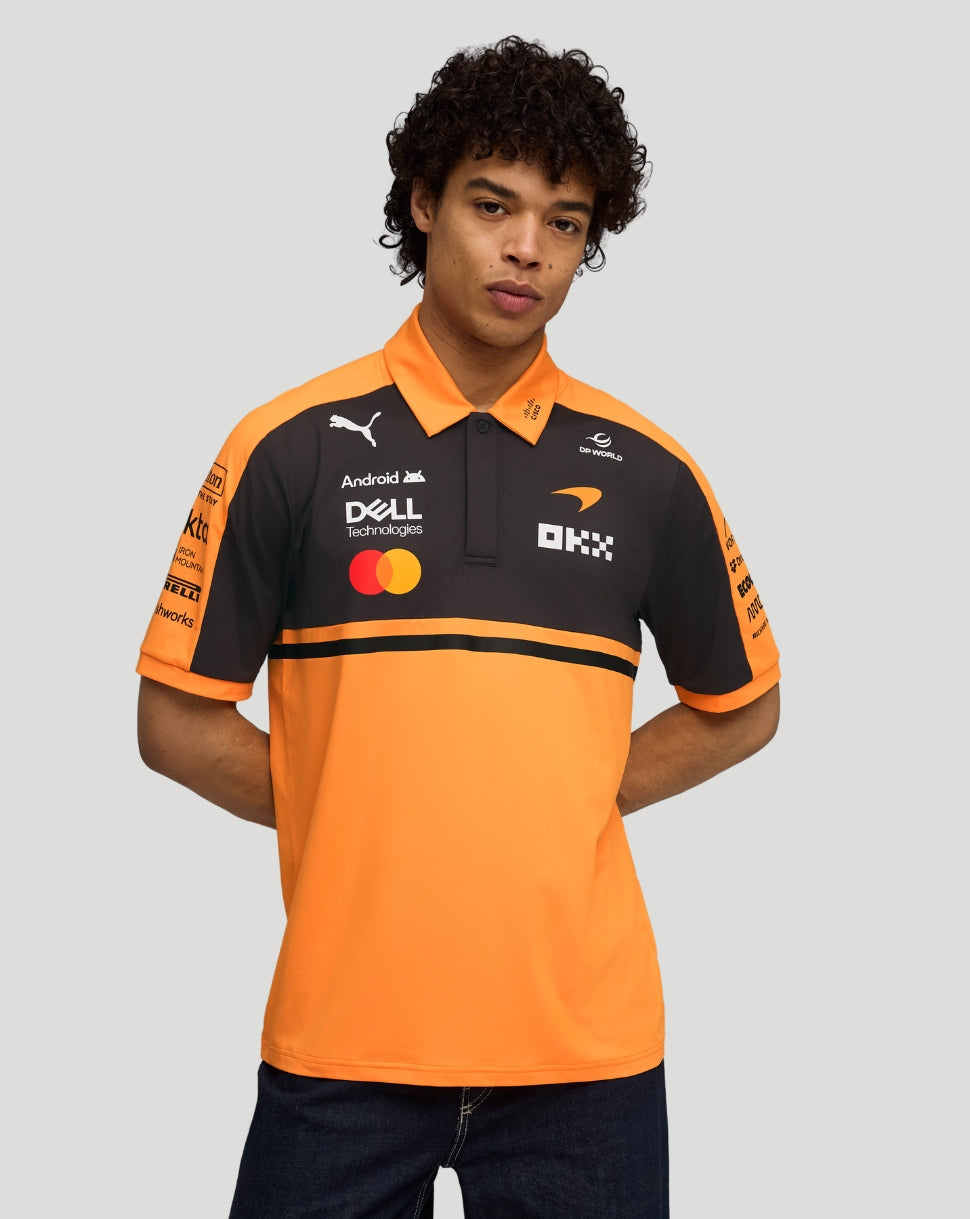 Male model wearing papaya orange McLaren Team Polo with black chest panel and sponsor logos.