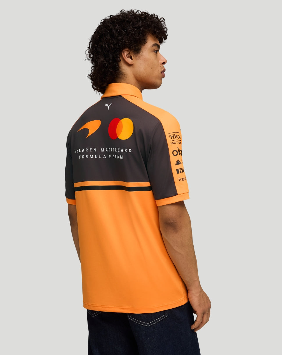 Back view of male model wearing papaya orange McLaren Team Polo with sponsor logos across the back.