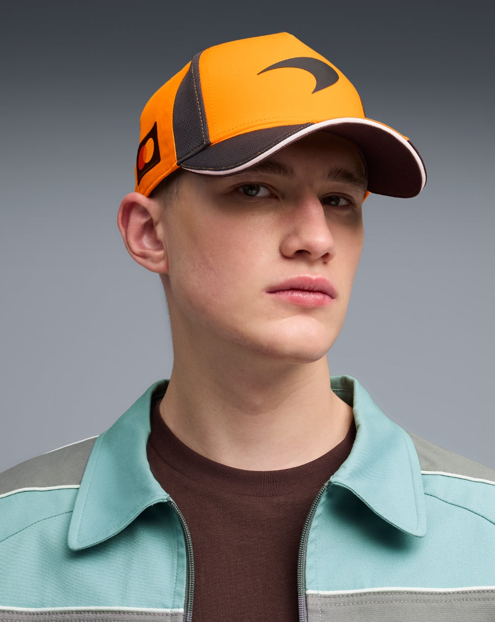 McLaren Papaya unisex team baseball cap worn by a model with orange panels black side accents and a white trimmed brim