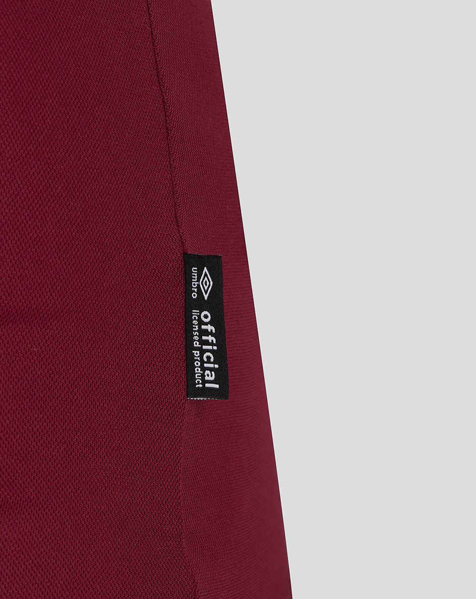 Close-up of burgundy fabric with official licensed product label along the side seam