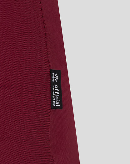 Close-up of burgundy fabric with official licensed product label along the side seam