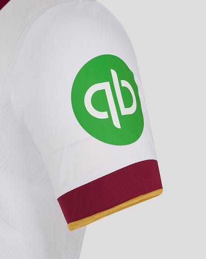 Close up of a white West Ham third jersey sleeve showing a green circular sponsor patch and maroon cuff with gold edge
