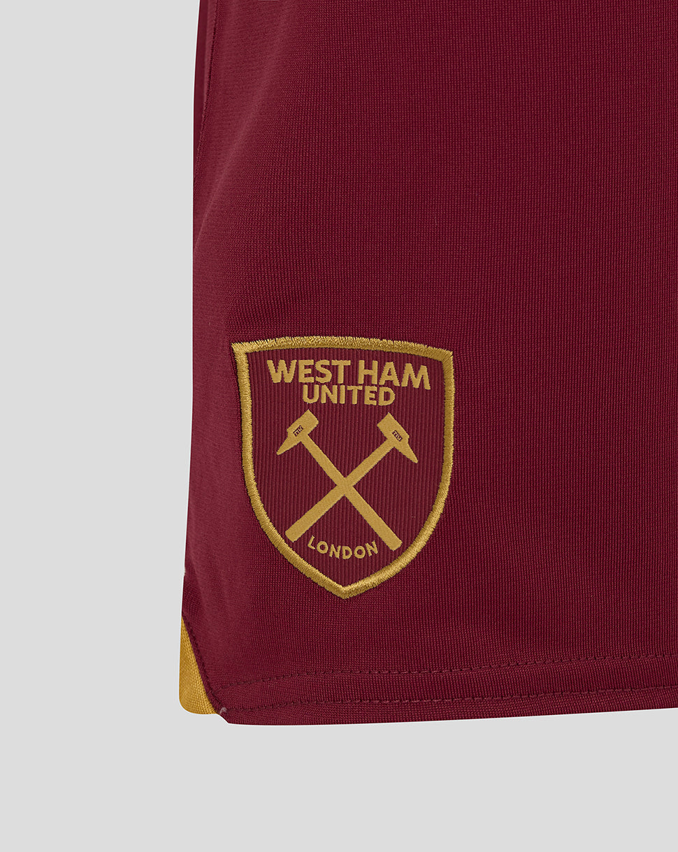 Gold West Ham crest embroidered on burgundy fabric at the shorts hem