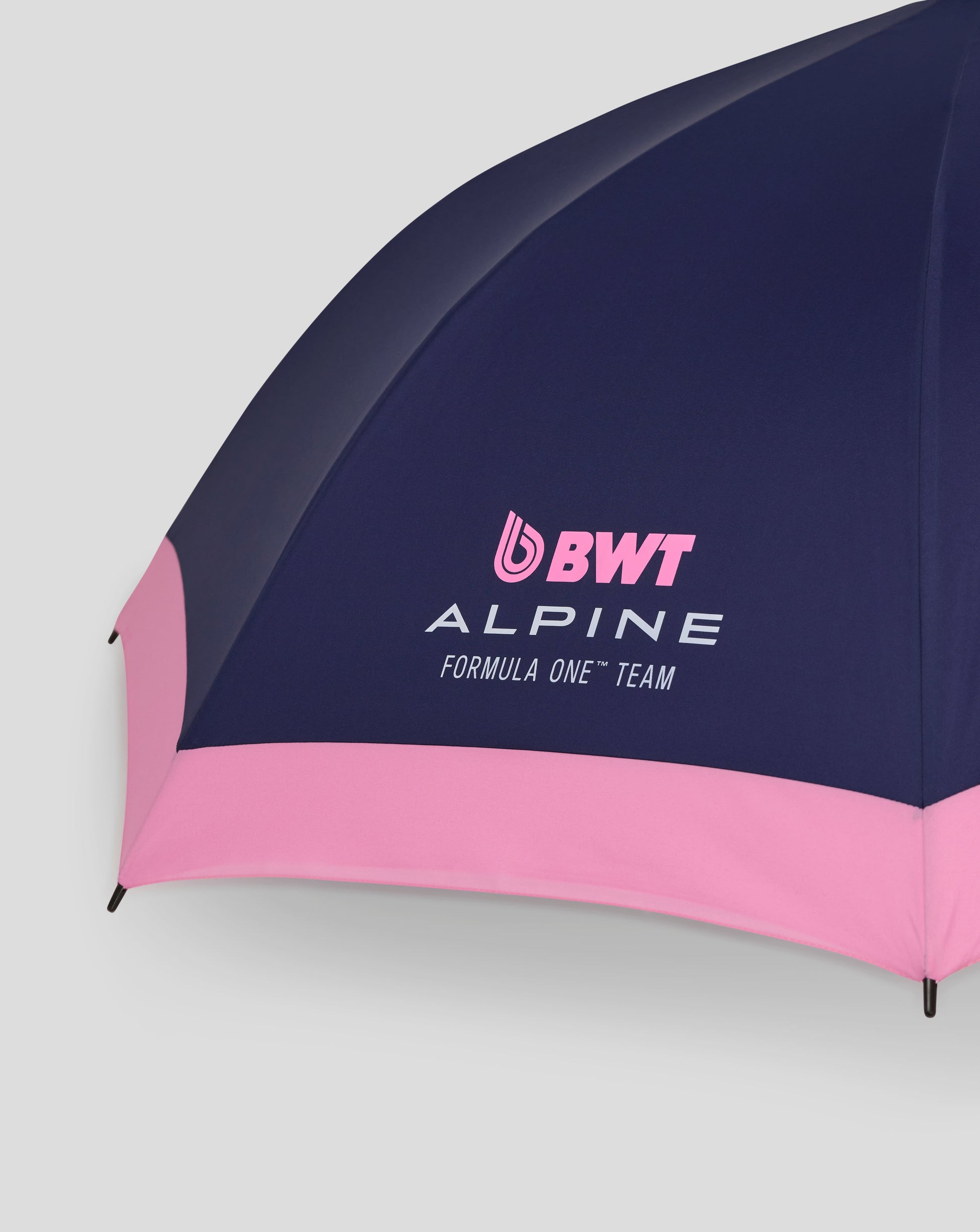 Navy BWT Alpine umbrella close up showing curved canopy with pink logo and Alpine branding.