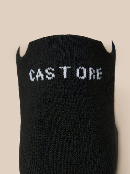 Close-up of a black Castore X Millburn trainer liner sock with white logo lettering