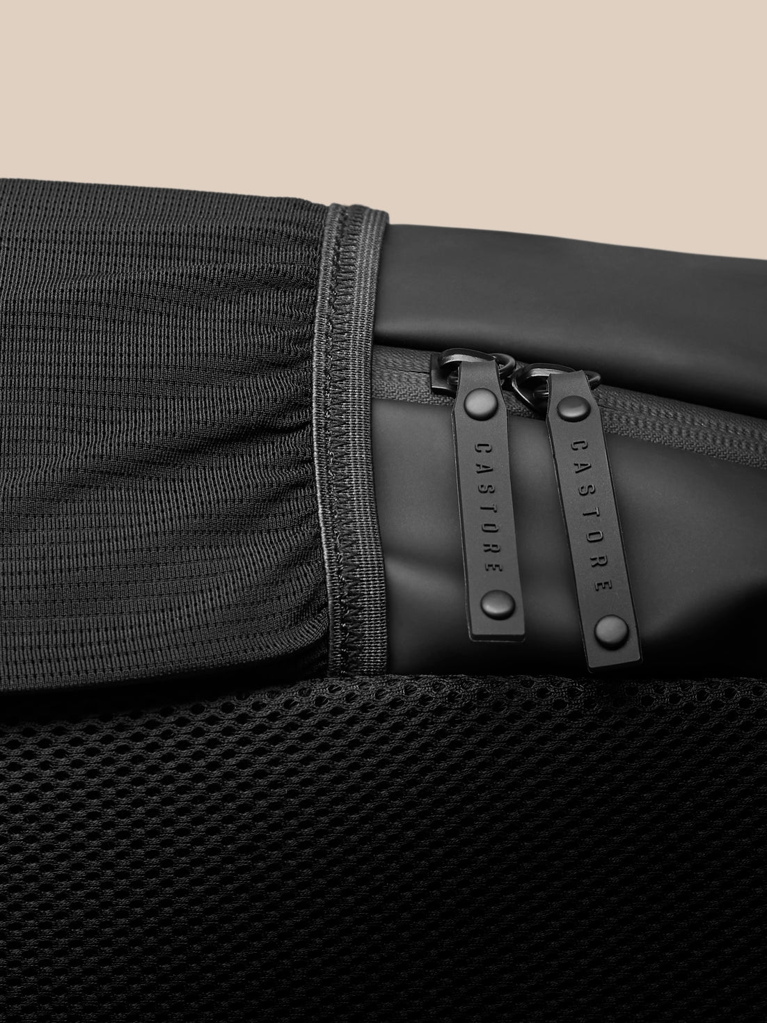 Close up of dual zippers with Castore branded pulls on the black Core Backpack.