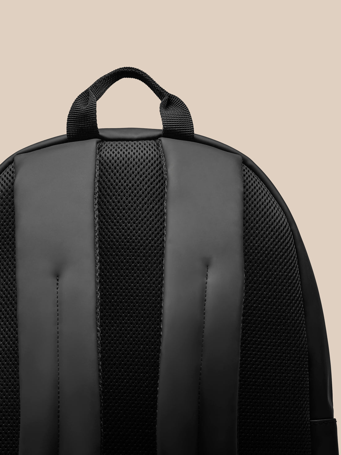 Back view of black Core Backpack showing padded back panel and adjustable padded shoulder straps.