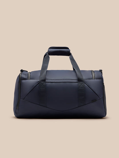 Core Holdall in navy with padded handles and an adjustable shoulder strap against a beige background