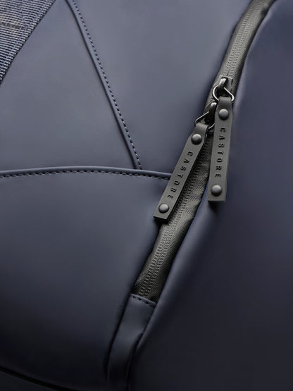 Detail of navy holdall zipper with CASTORE branded pulls and a mesh side pocket