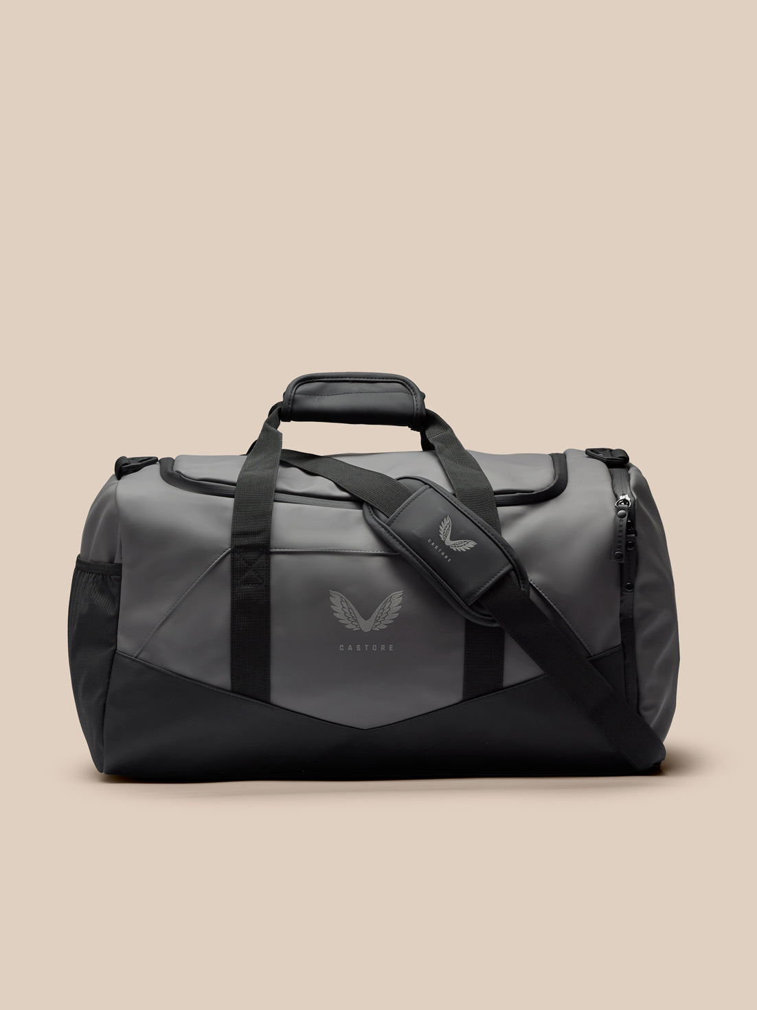 Core Holdall in gunmetal gray and black with padded grab handle, detachable shoulder strap, and a silver wing logo on the front.