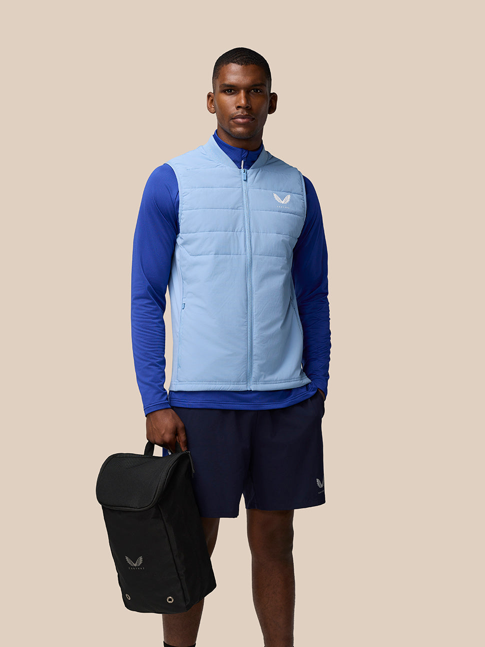 Athletic model wearing blue training gear carries a black Active Boot Bag by the side
