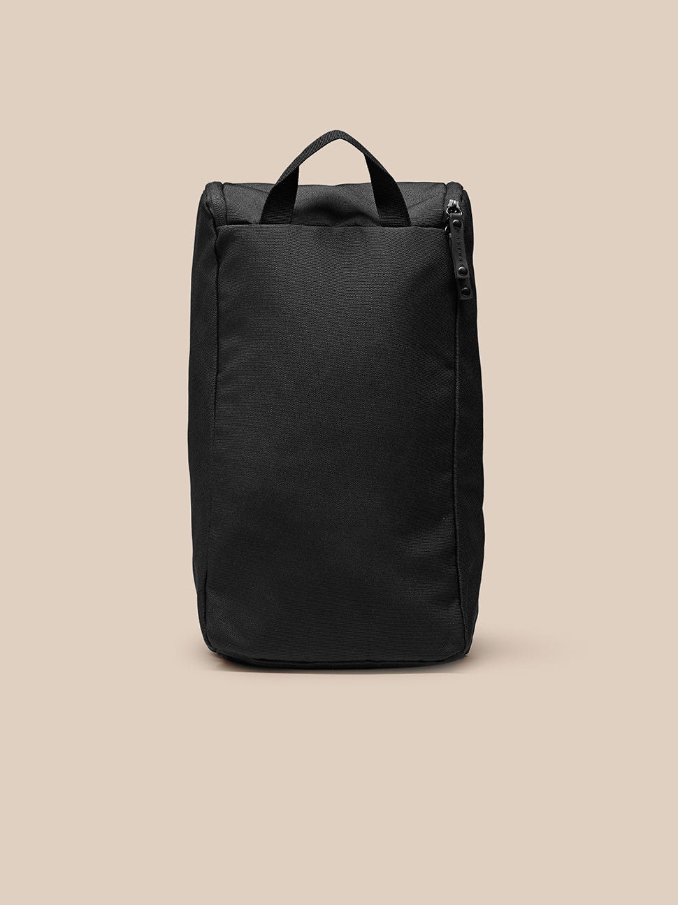 Model in blue athletic wear holds the black Active Boot Bag by the top handle