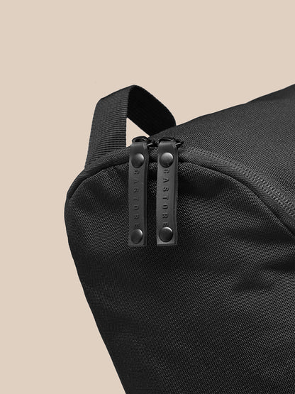 Close-up of black Active Boot Bag showing durable woven fabric and dual zipper pulls with top strap
