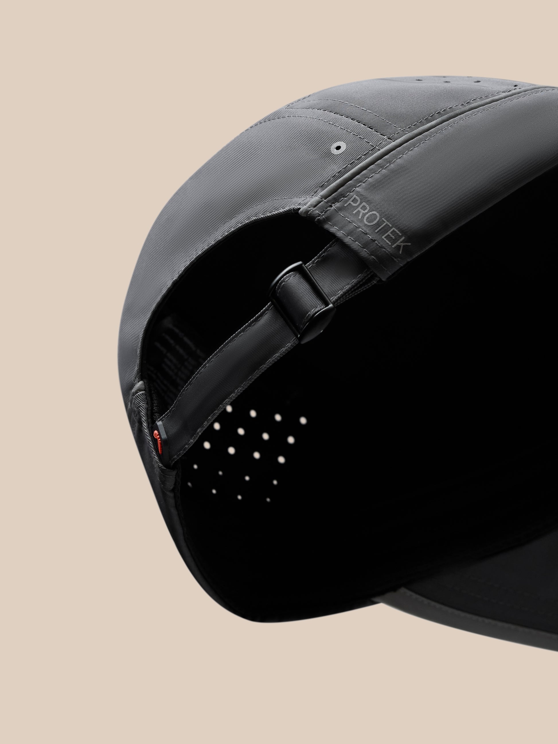 Close-up of the back of a gunmetal unisex elevated cap with adjustable strap, metal buckle, and halo eyelets