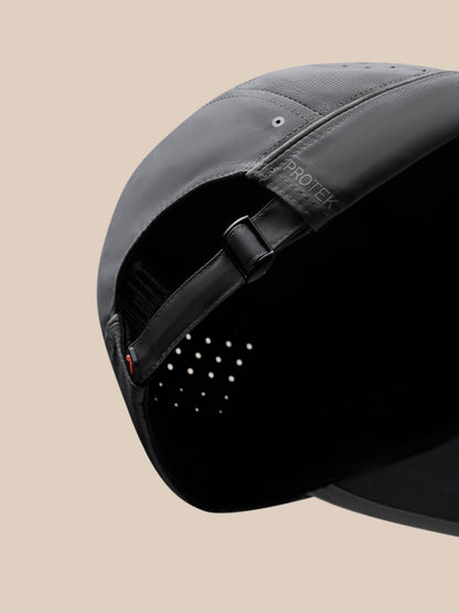Close-up of the back of a gunmetal unisex elevated cap with adjustable strap, metal buckle, and halo eyelets