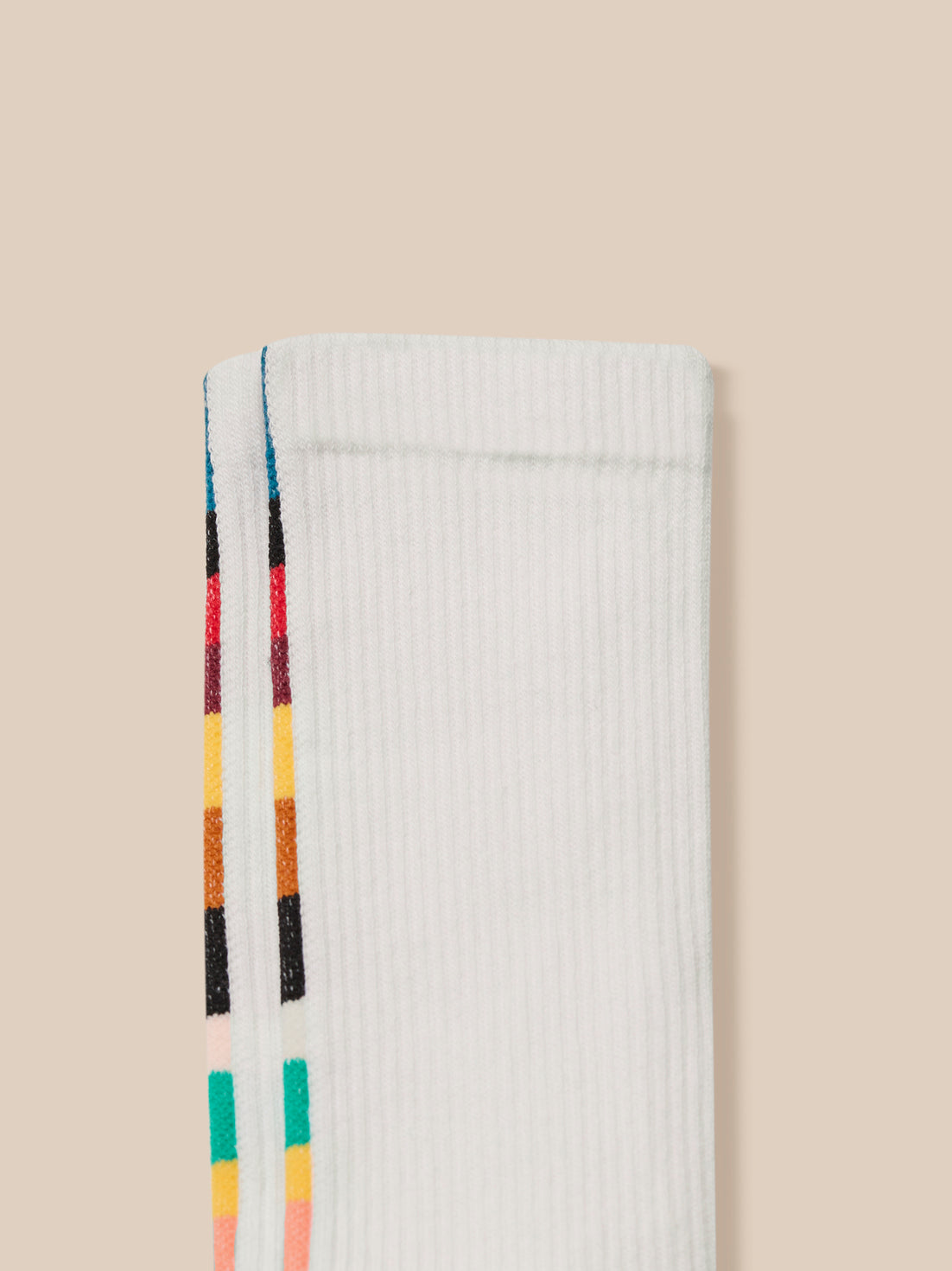 White Castore x Paul Smith technical sock with multicolor stripes along the side and teal edging at the top