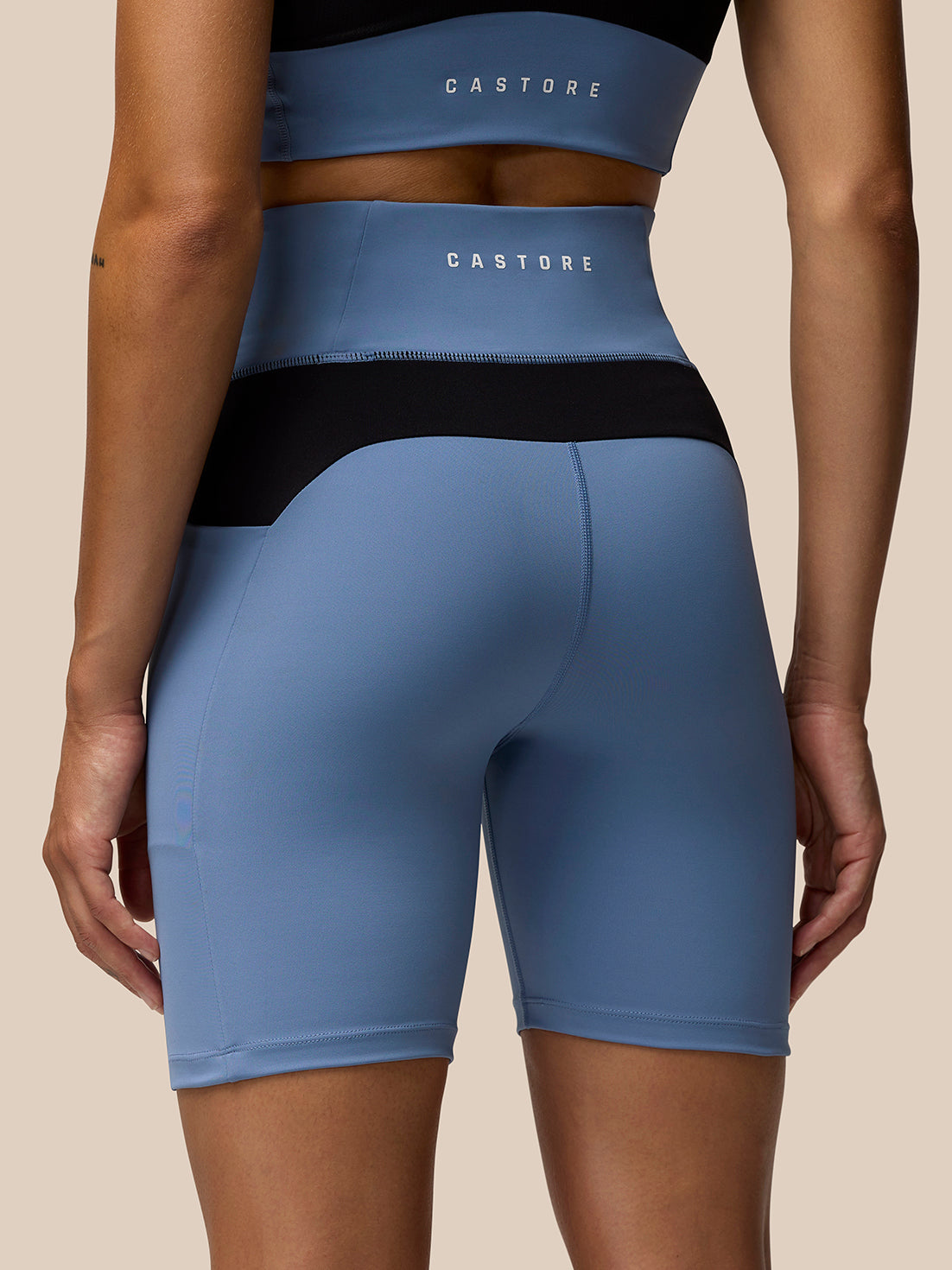 Back view of light blue Apex Training Cycle Shorts with a phone in the side pocket