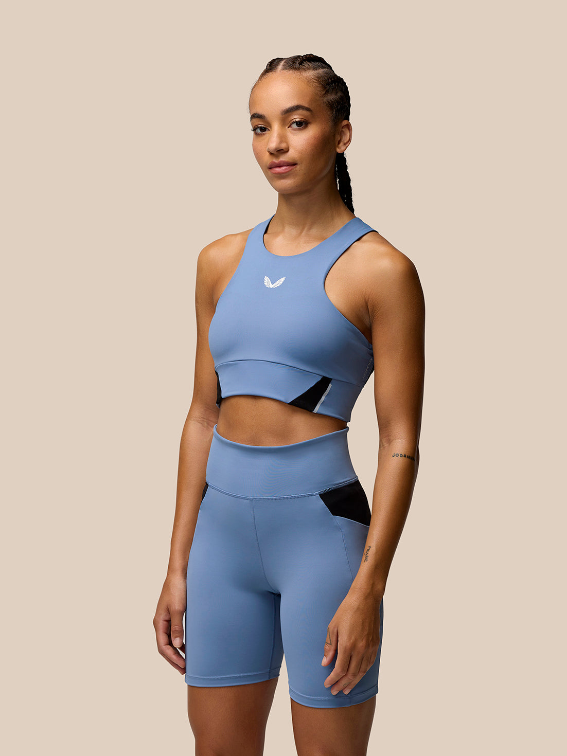 Woman wearing Dove Blue Apex Training Cycle Shorts with black side panels front view