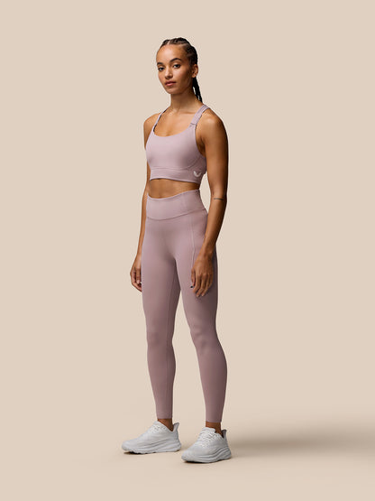 Front view of a woman in pink Zone full-length training leggings and matching sports bra for a workout