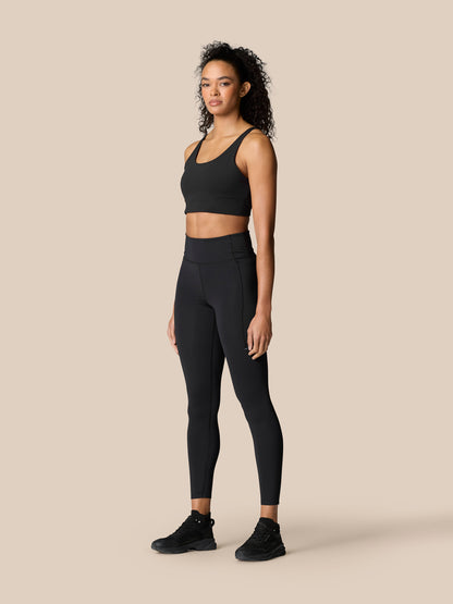 Model wearing black Zone Training Leggings and matching top in a neutral studio setting