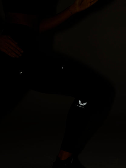 Dark shot of a person wearing black Zone Training Leggings with a small Castore logo on the thigh