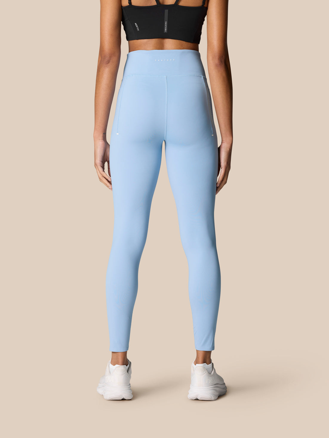 Back view of light blue Zone Training Leggings on a model, high waistband with Castore logo and seam details