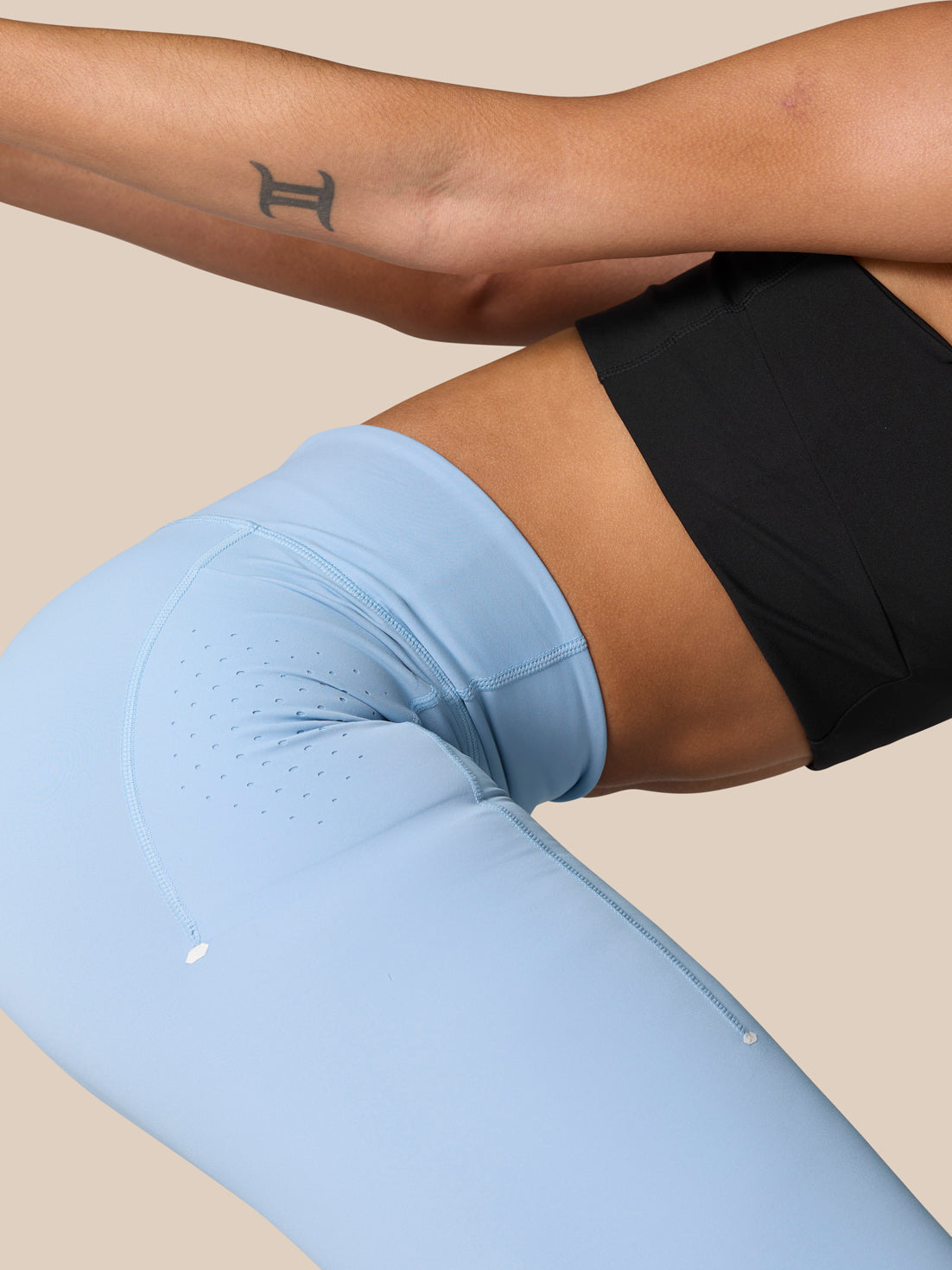 Close-up of the side pocket on sky blue Zone Training Leggings showing perforated vent details and a phone tucked into the pocket.