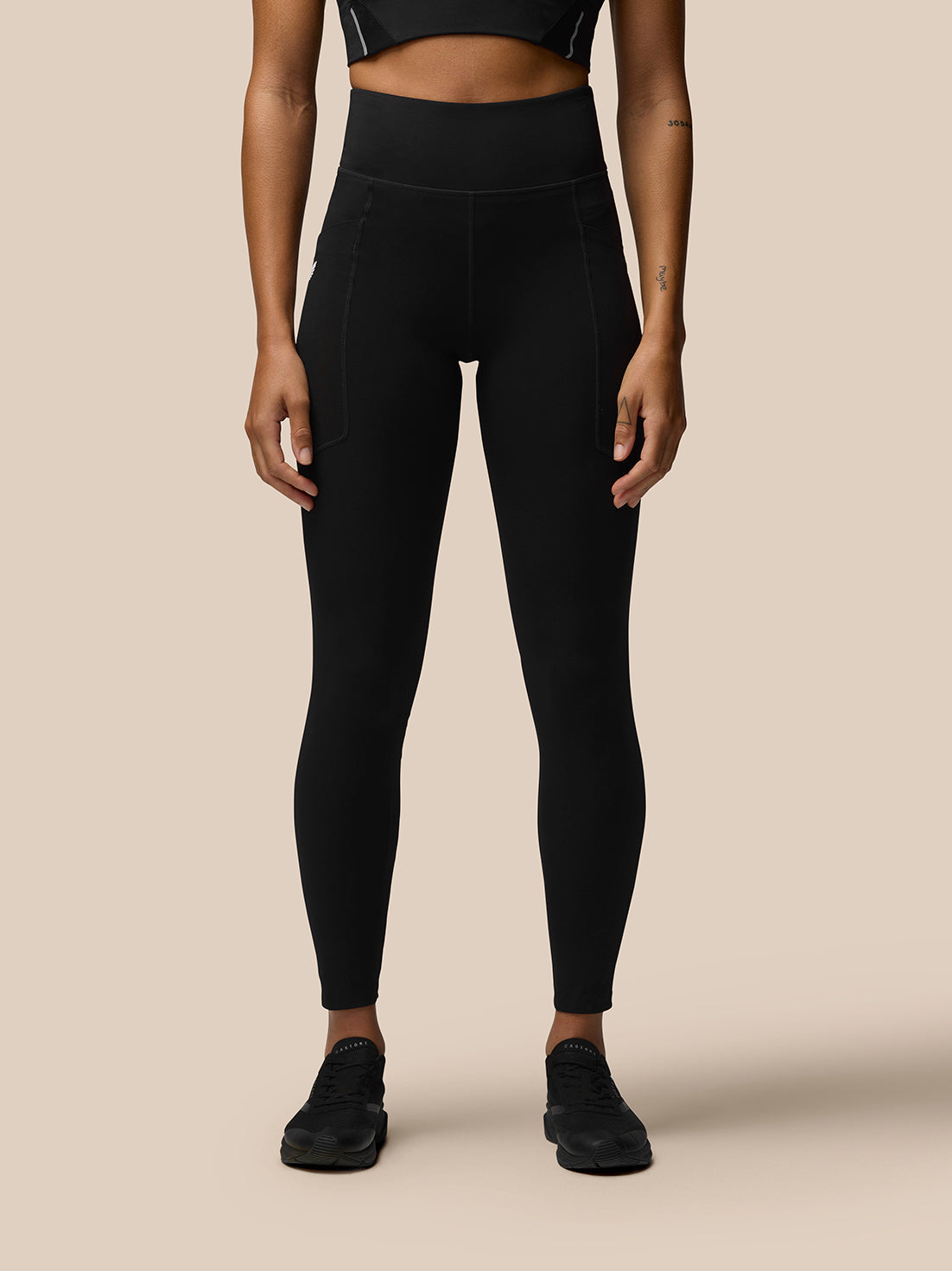 Back view of a model in black Apex Training Leggings with a high waistband and Castore branding on the right thigh