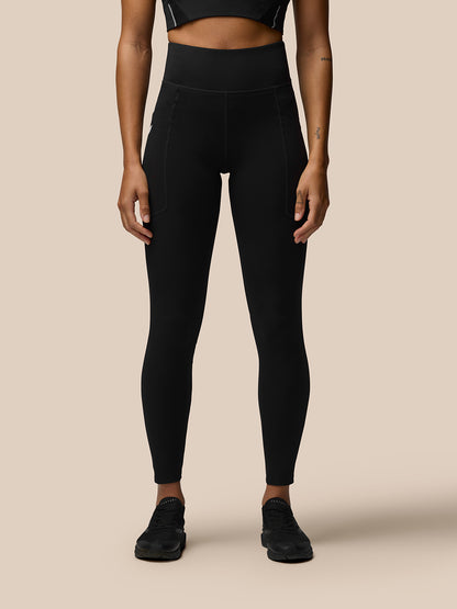 Back view of a model in black Apex Training Leggings with a high waistband and Castore branding on the right thigh