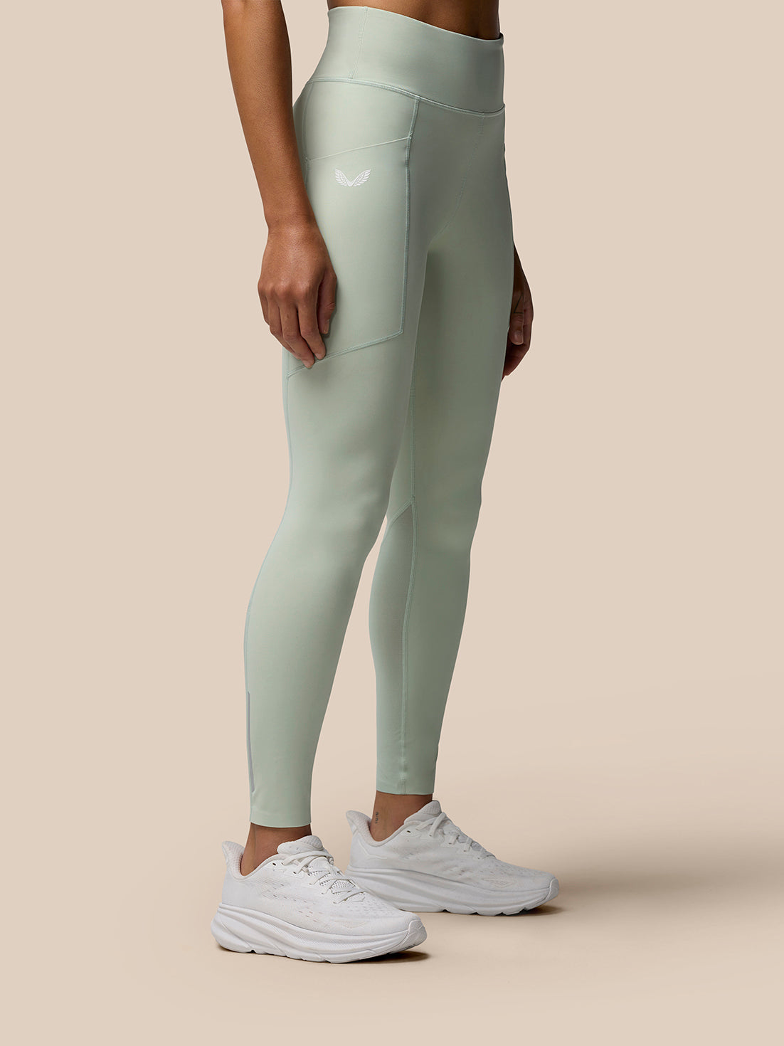 Side view of Sage Apex leggings highlighting side seams and a small logo on the thigh.