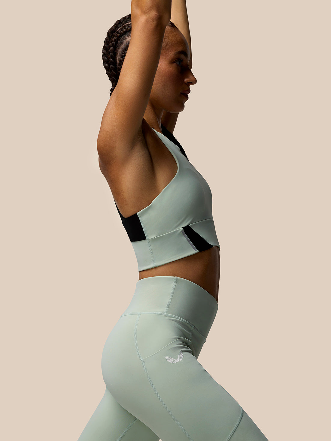 Profile view of a model in Sage Apex leggings showing the high waist and panel seam details.