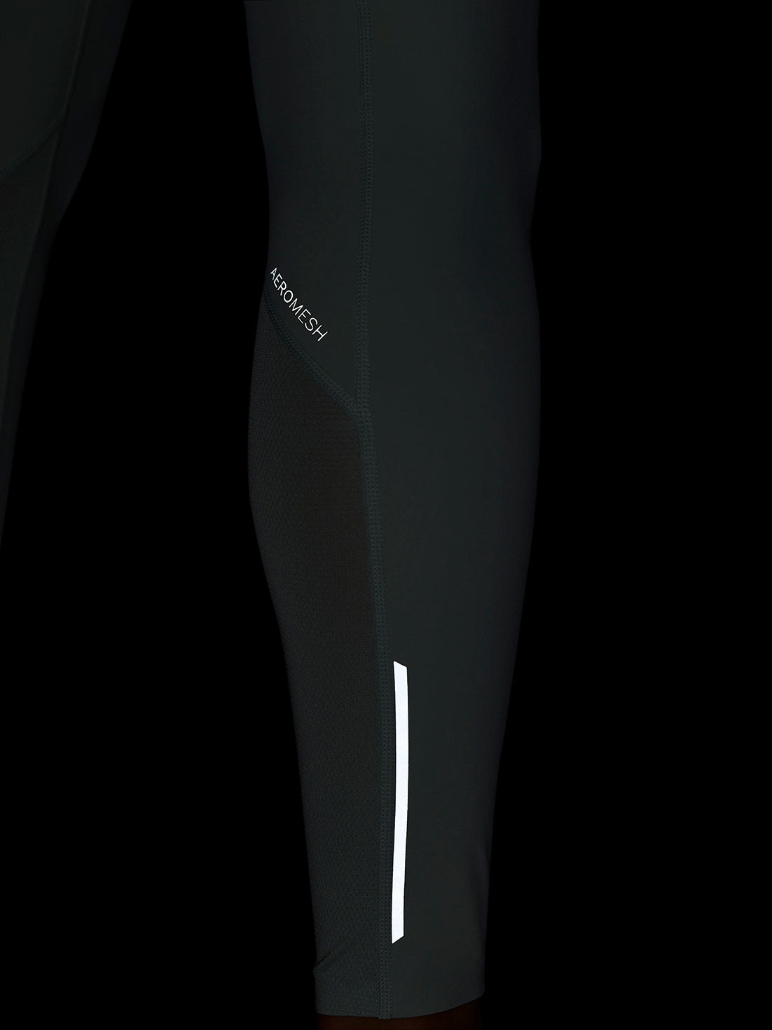 Close-up of Apex Training Leggings showing Aeromesh paneling and a white reflective stripe on the lower leg