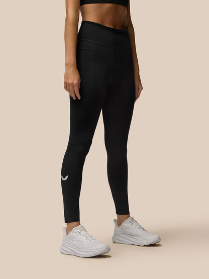 Back view of black Flow Movement leggings on a model with leg pocket detail and calf logo