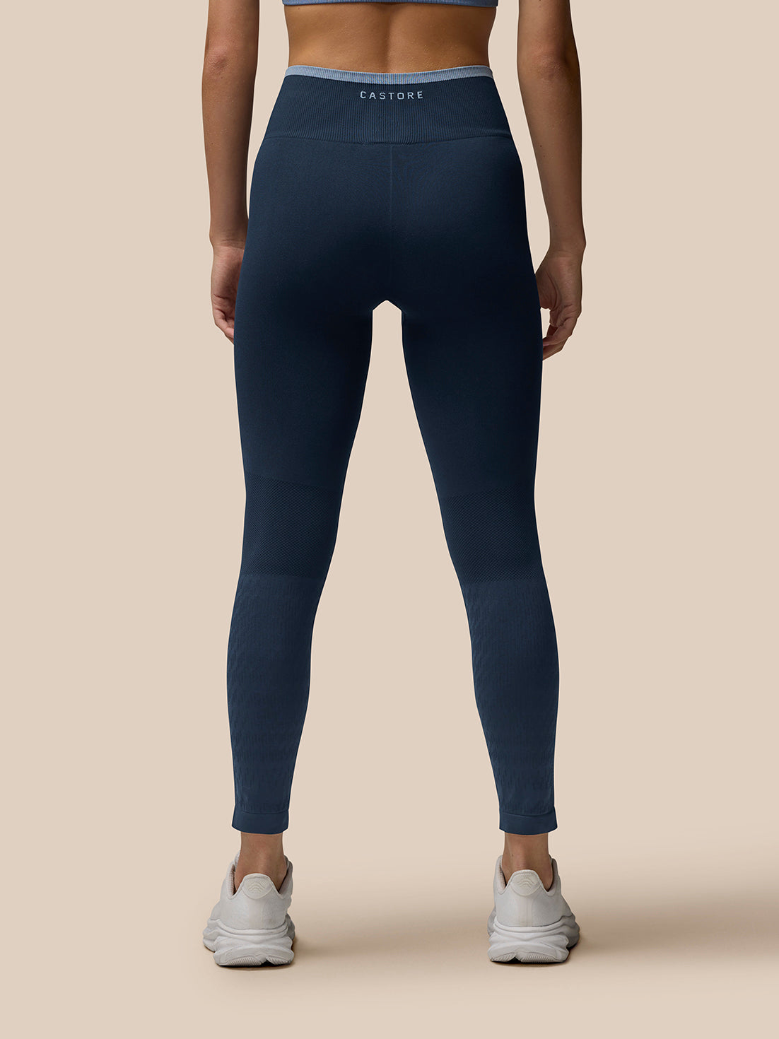 Back view of navy Flow Training ⅞ leggings with ribbed waistband and Castore branding.
