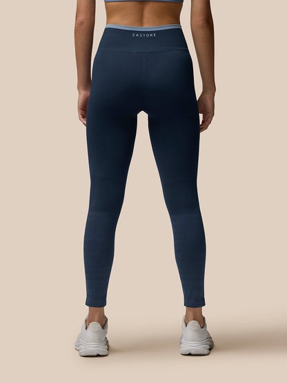 Back view of navy Flow Training ⅞ leggings with ribbed waistband and Castore branding.