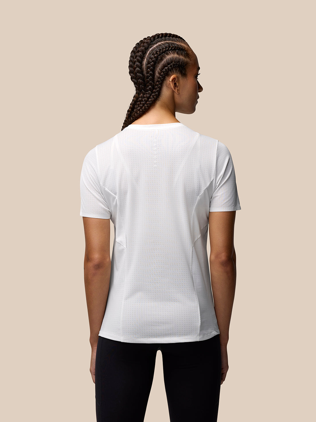 Back view of a model wearing a white Apex Training T Shirt with center back Castore branding and AeroMesh panels