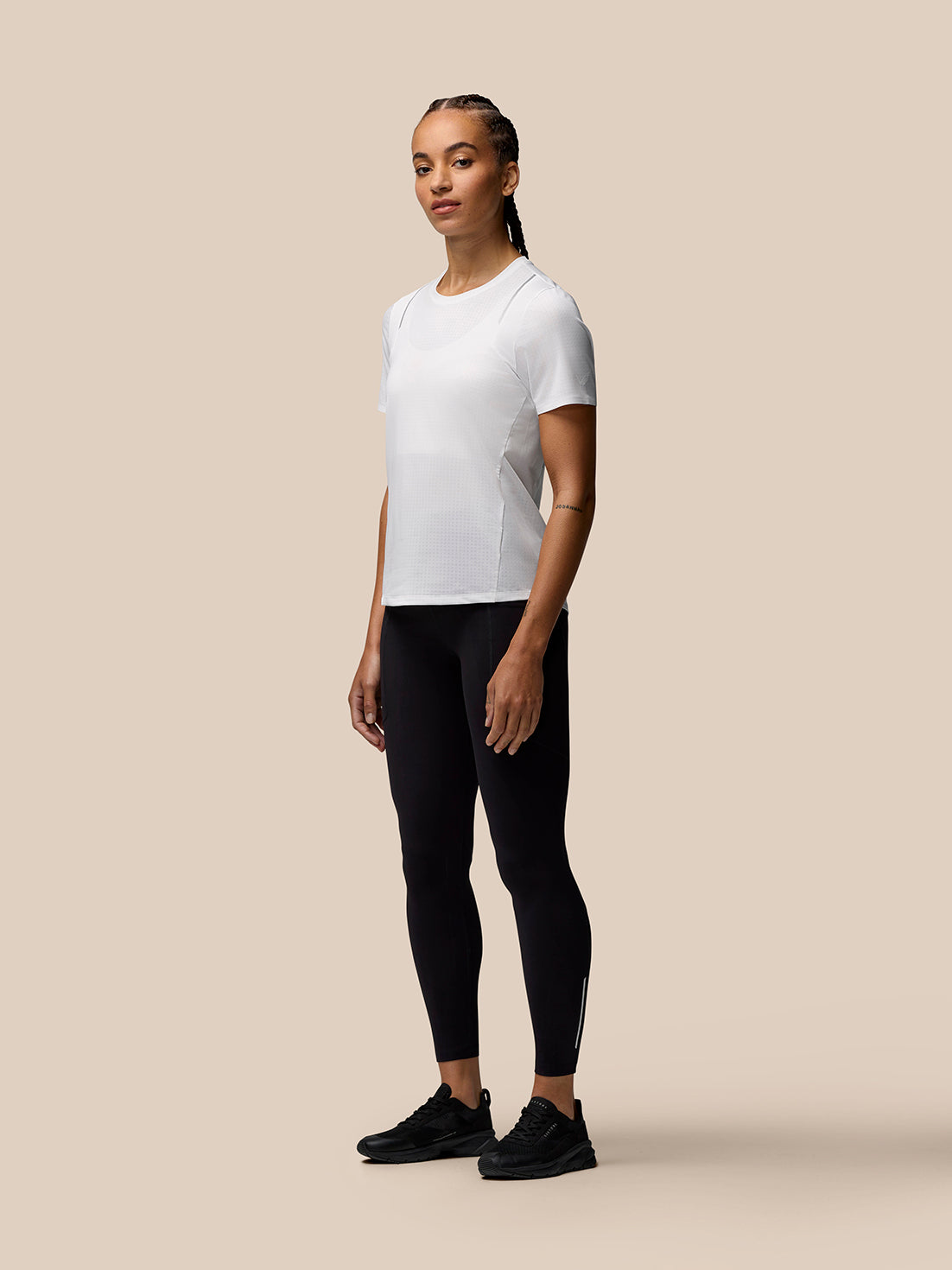 Female model wearing white Apex Training T Shirt with crew neck and dropped hem.