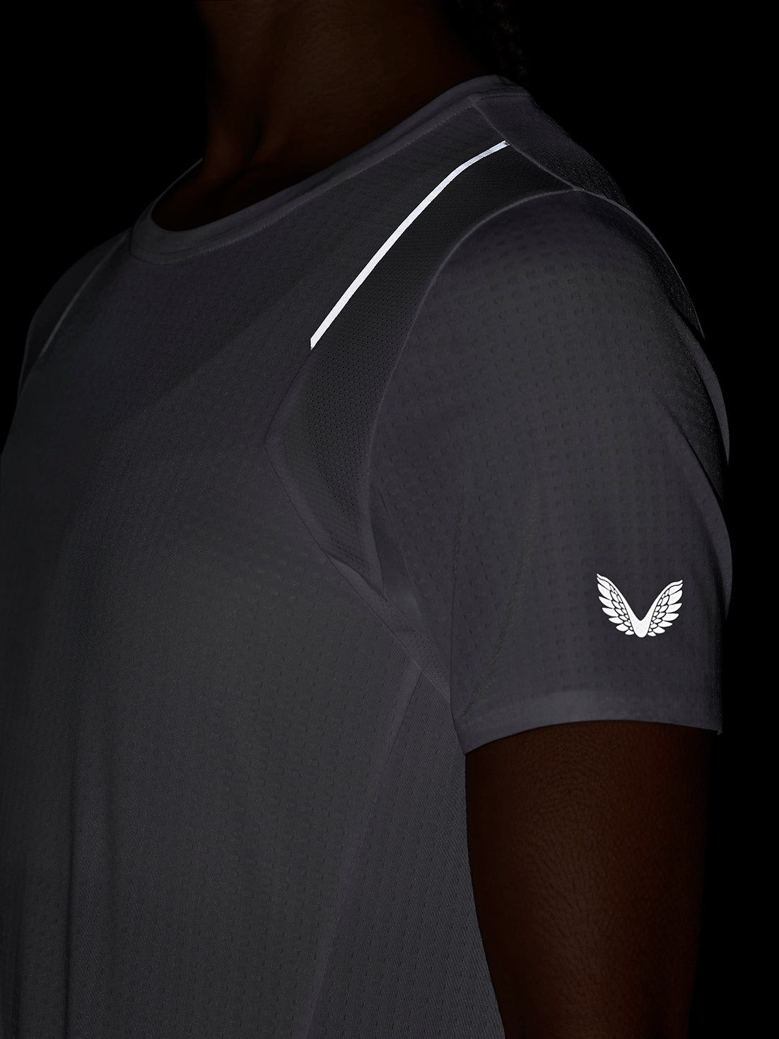 Close up of dark Apex Training T Shirt shoulder with white stripe and Castore wing logo on the sleeve.