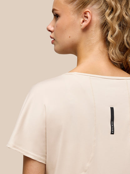 Side profile of beige Flow Training T Shirt with Castore branding on the back waist.