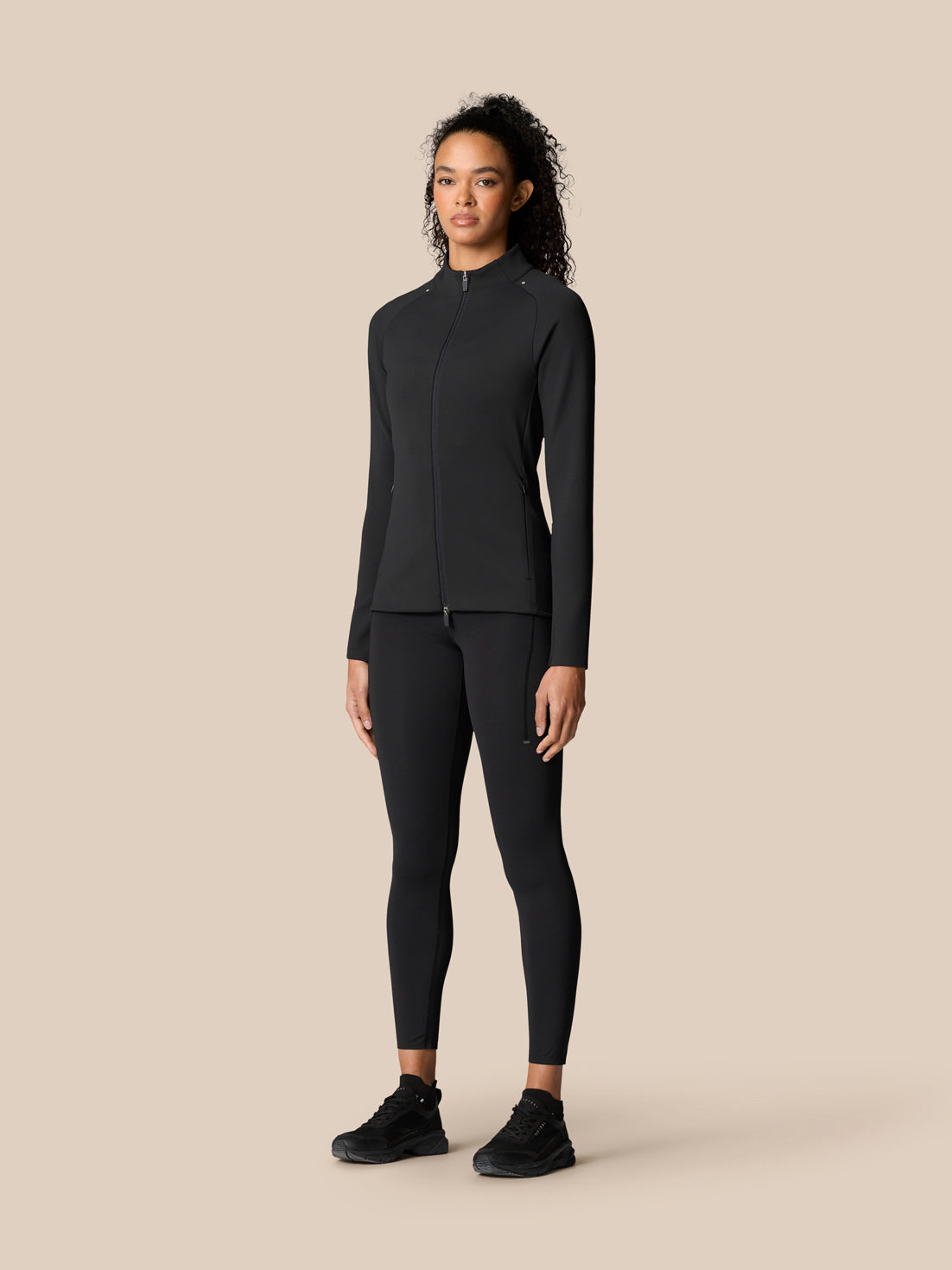 Full-body shot of a model in a black Zone Training set with top and matching leggings for training