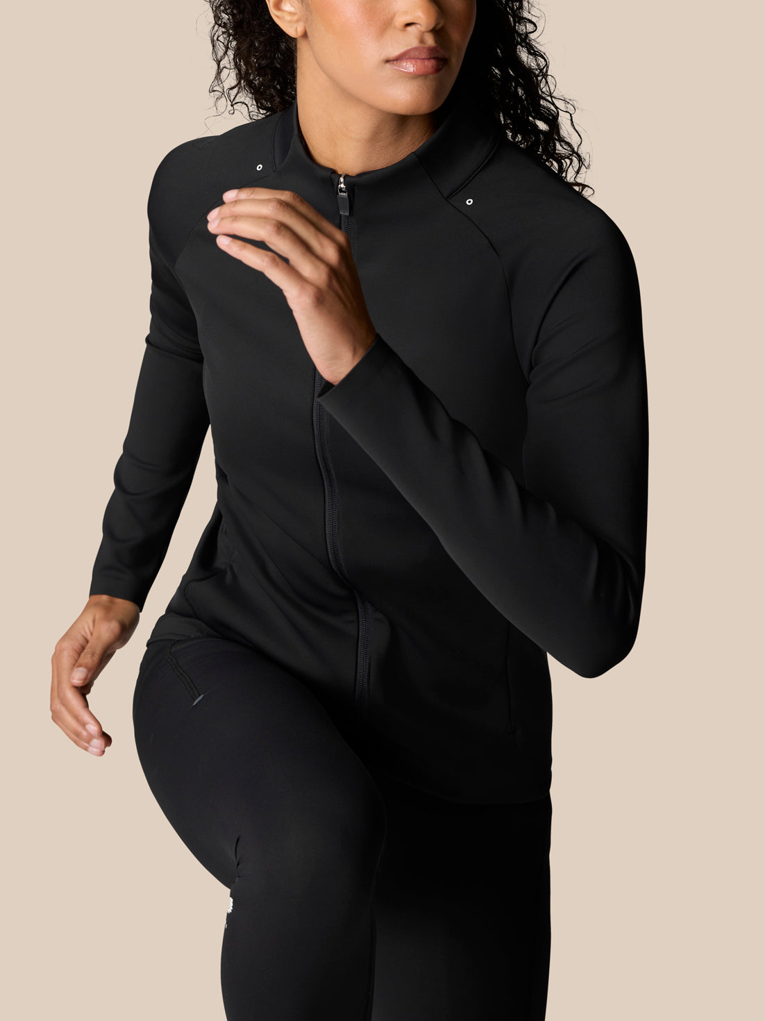 Model wearing Zone Training Top in black with full zip front and bonded cuffs.