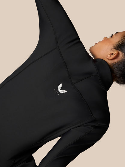 Close-up of black Zone Training Top showing shoulder seam details and a small white logo.