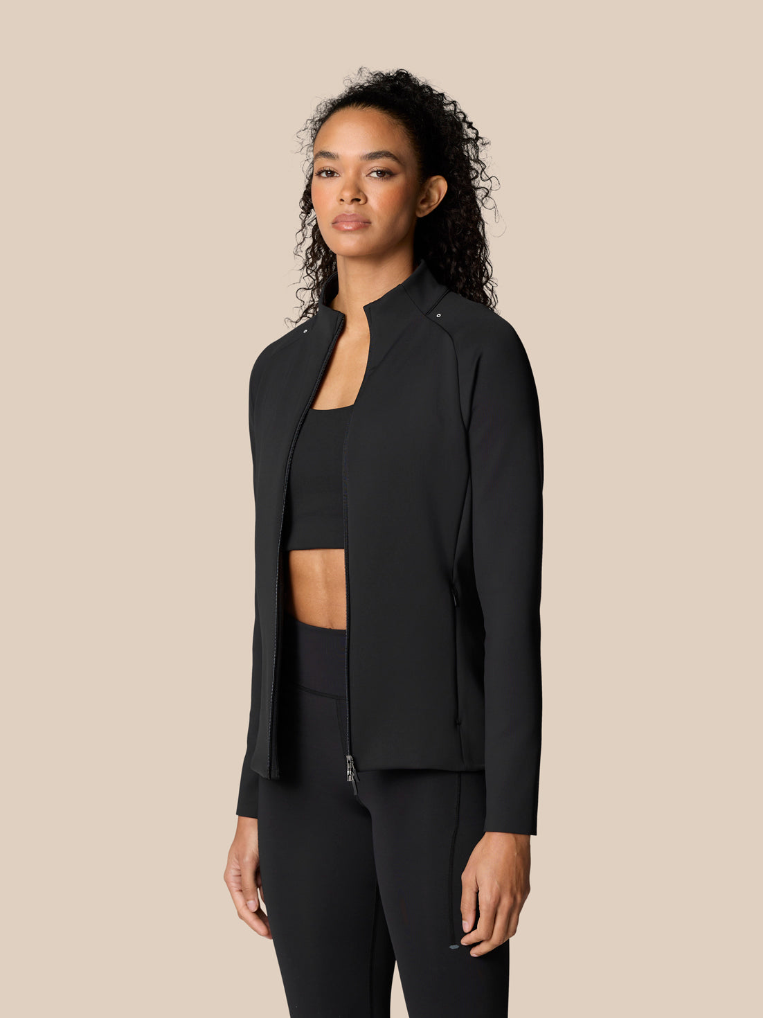 Female model wearing Zone Training Top Black full zip jacket with stand collar.