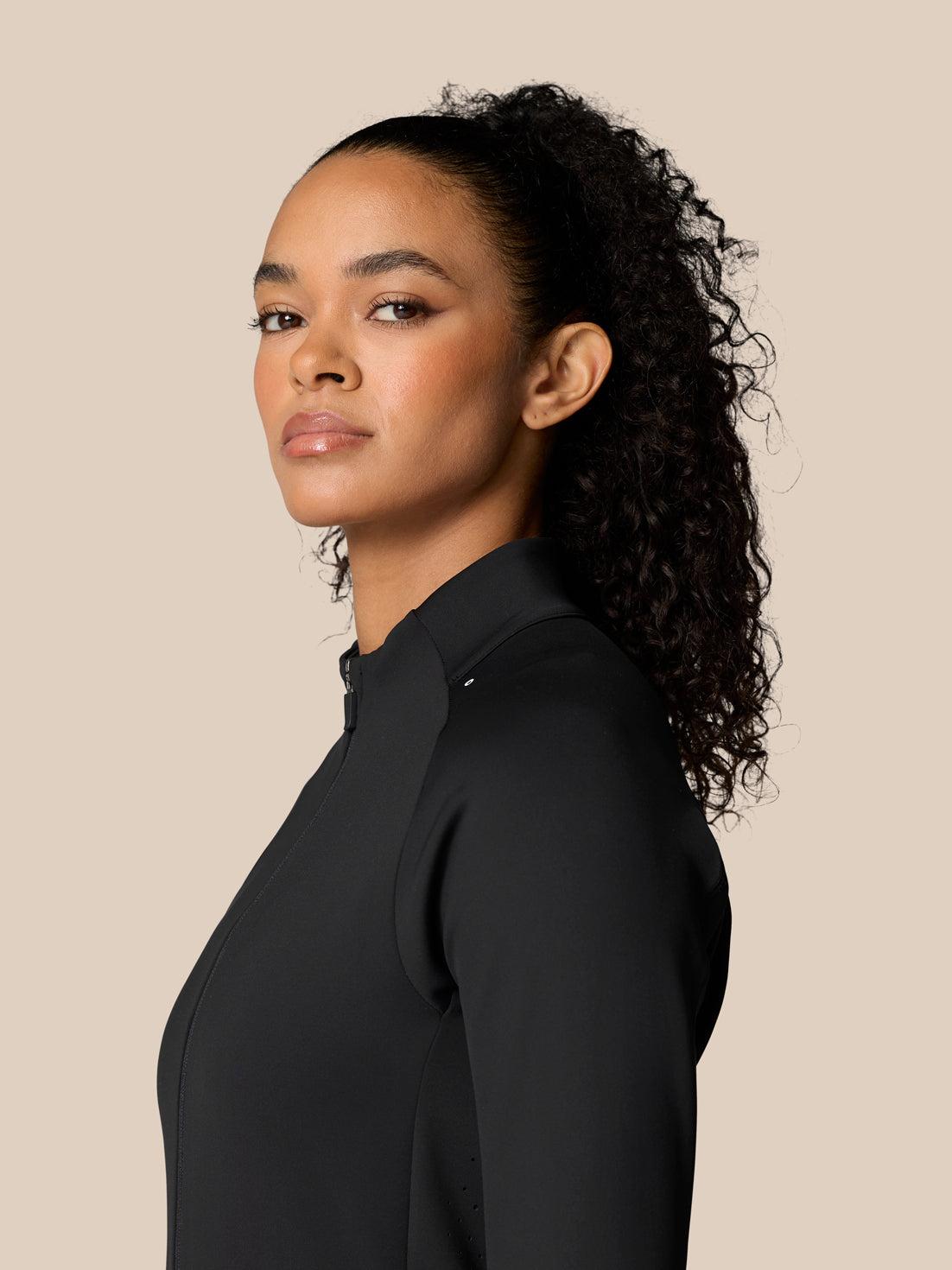 Side profile of a female model wearing Zone Training Top Black jacket with stand collar.