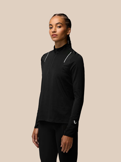 Model wearing black Apex Training 1/4 Zip Top with funnel collar and reflective shoulder details.